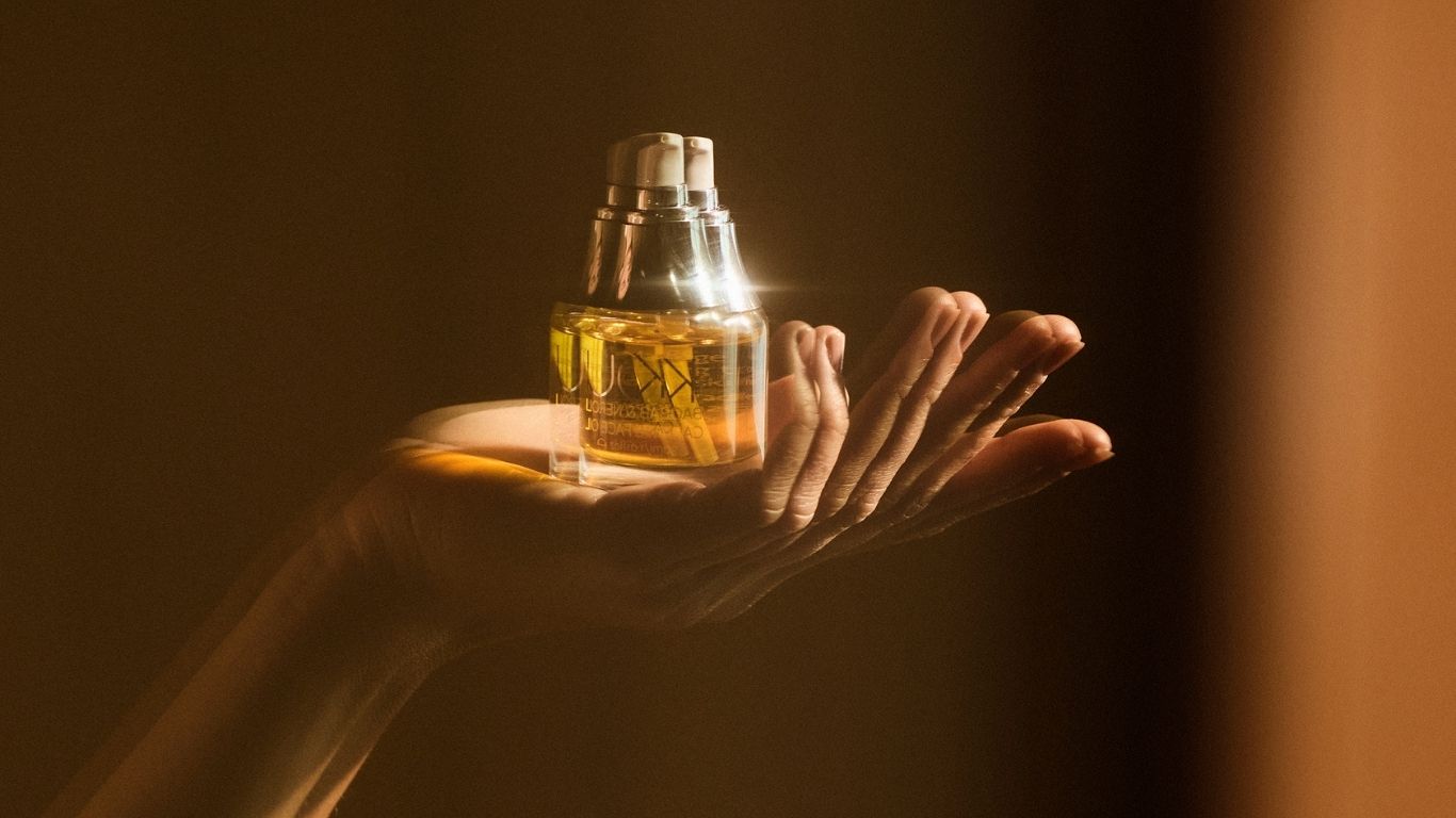 Hand holding a bottle of face oil 
