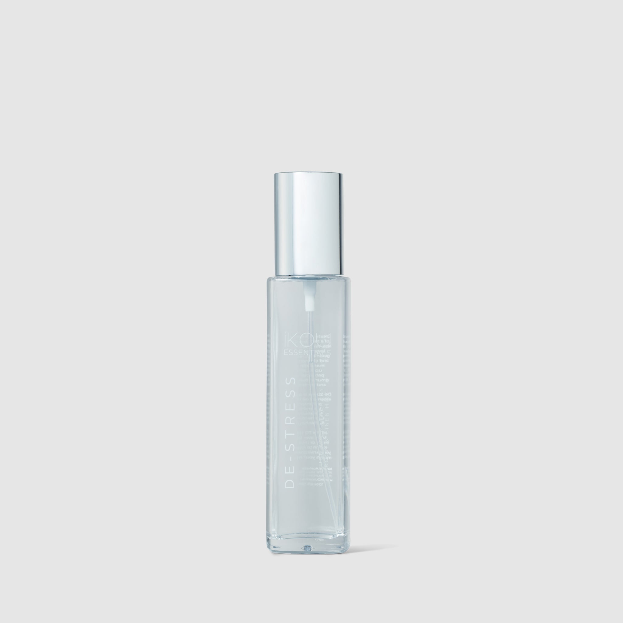 Clear glass bottle with silver cap on a light gray background