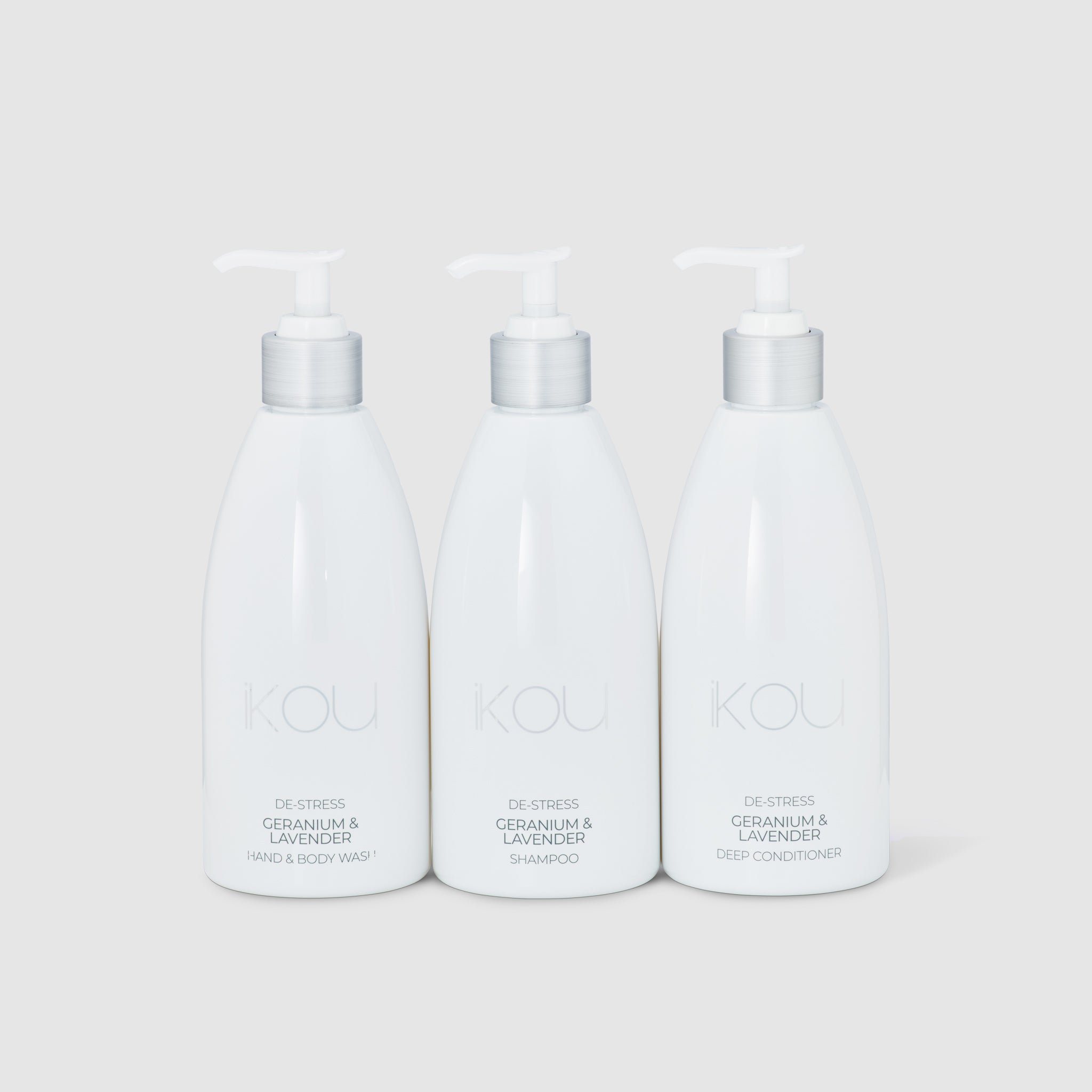Three white bottles of KOOL hair care products on a light gray background