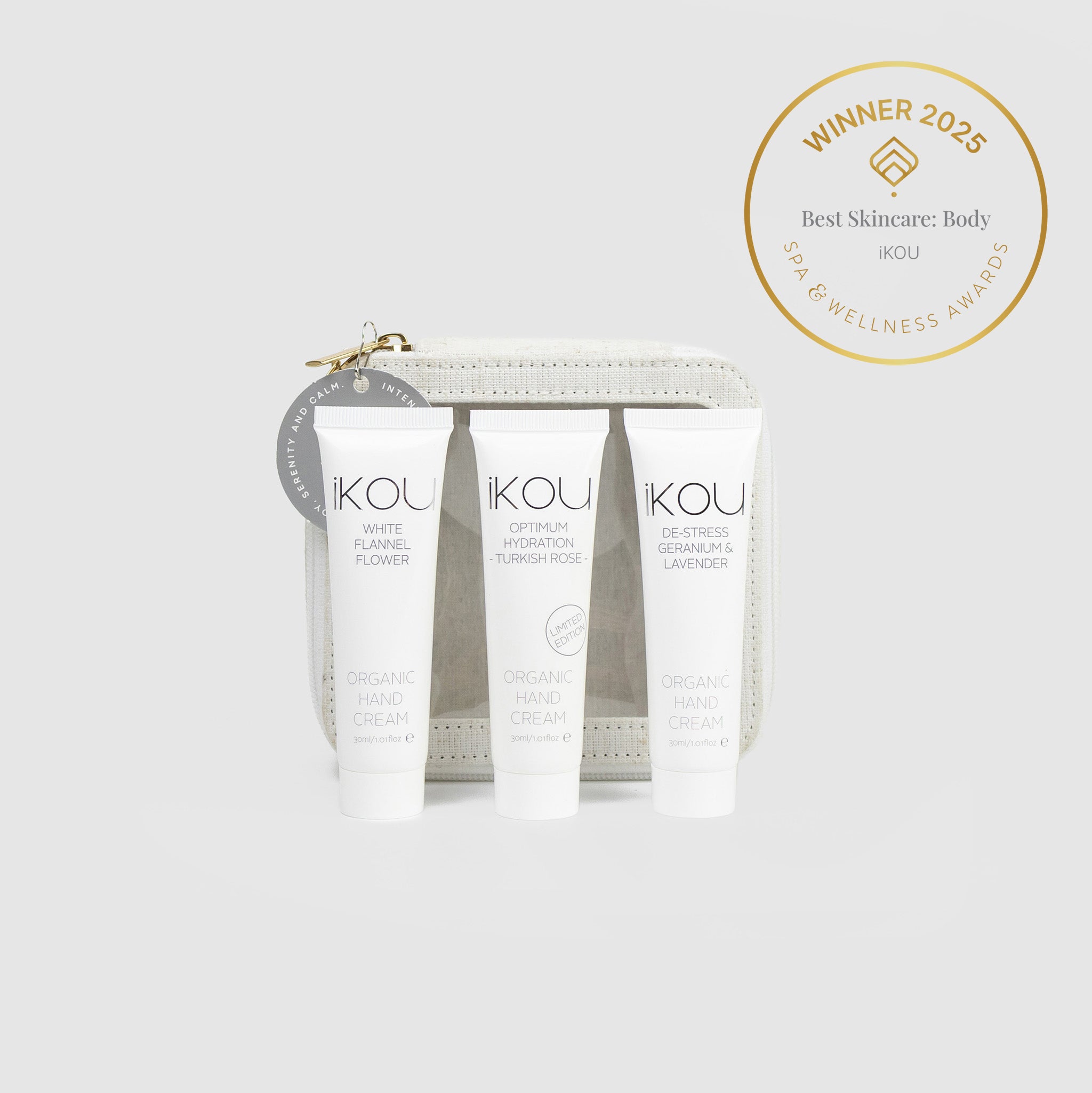 Three skincare products with 'IKOU' branding in front of a decorative box, featuring an award badge on a white background.