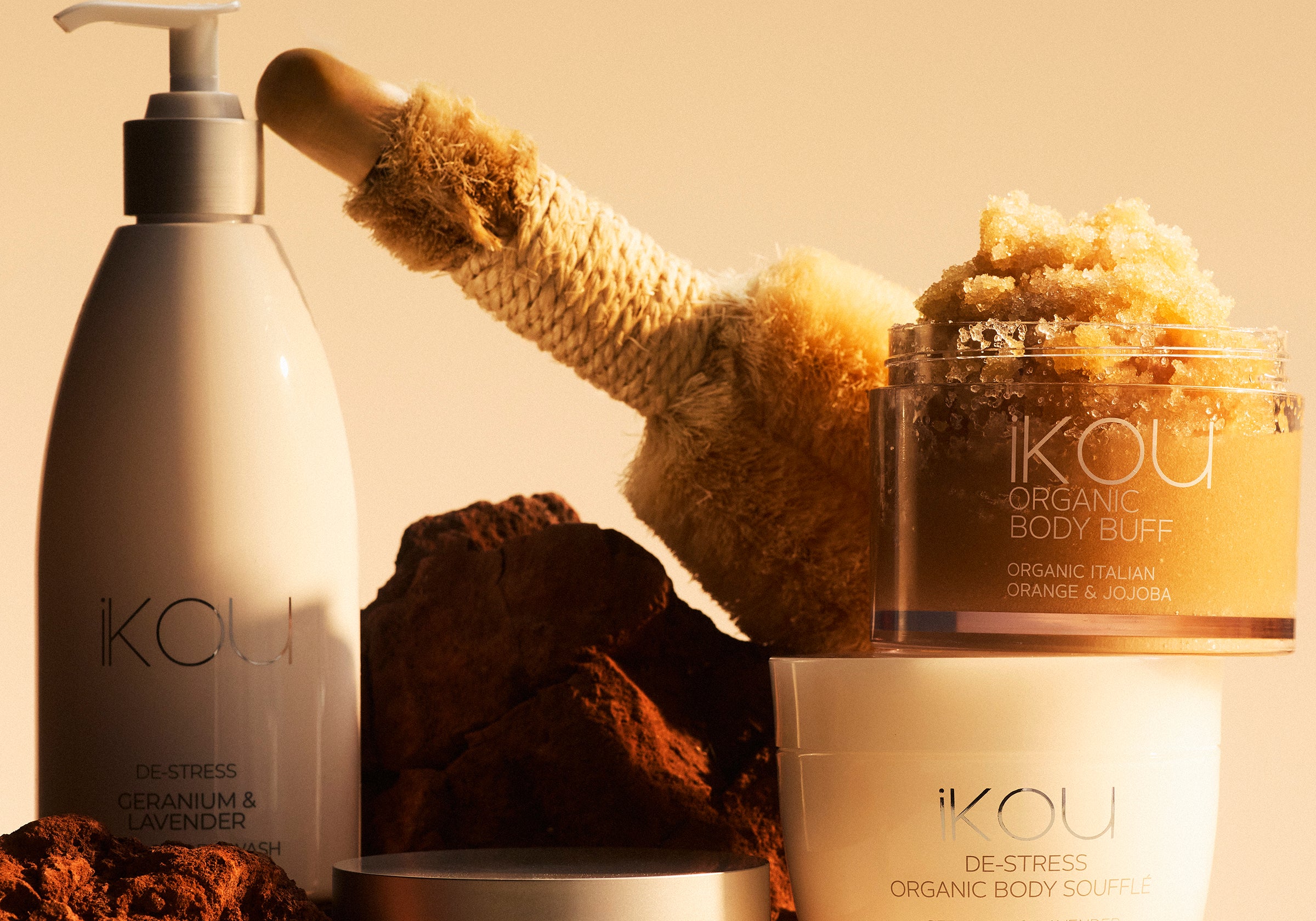 Ikou skincare products including a bottle, jar, and scrub on a beige background