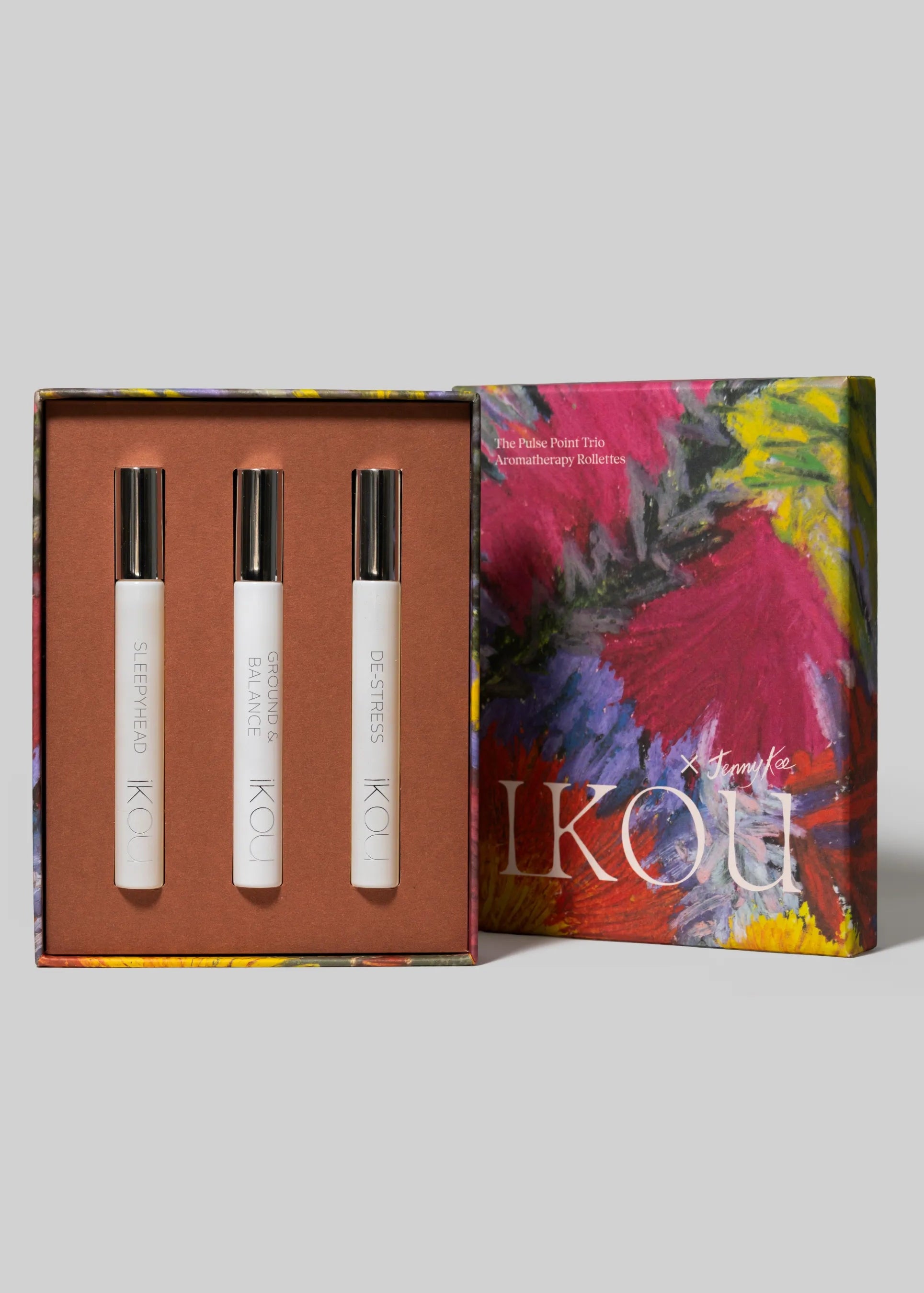 A boxed Roll on fragrance gift set. The set includes three white cylindrical perfume bottles with silver caps arranged in an open rectangular box, alongside the Jenny Kee outer box lid.