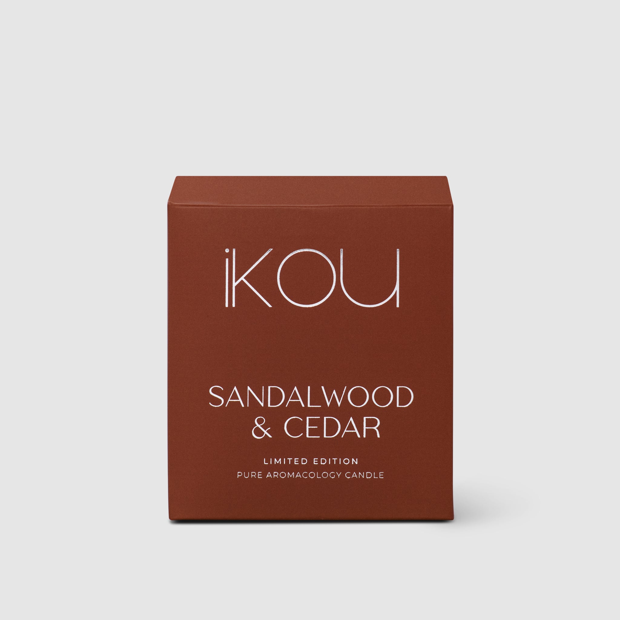 Brown box of 'IKOU' Sandalwood & Cedar candle on a light gray background