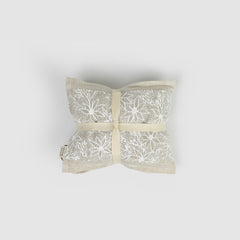 Decorative heat pack with white floral pattern on a light grey background