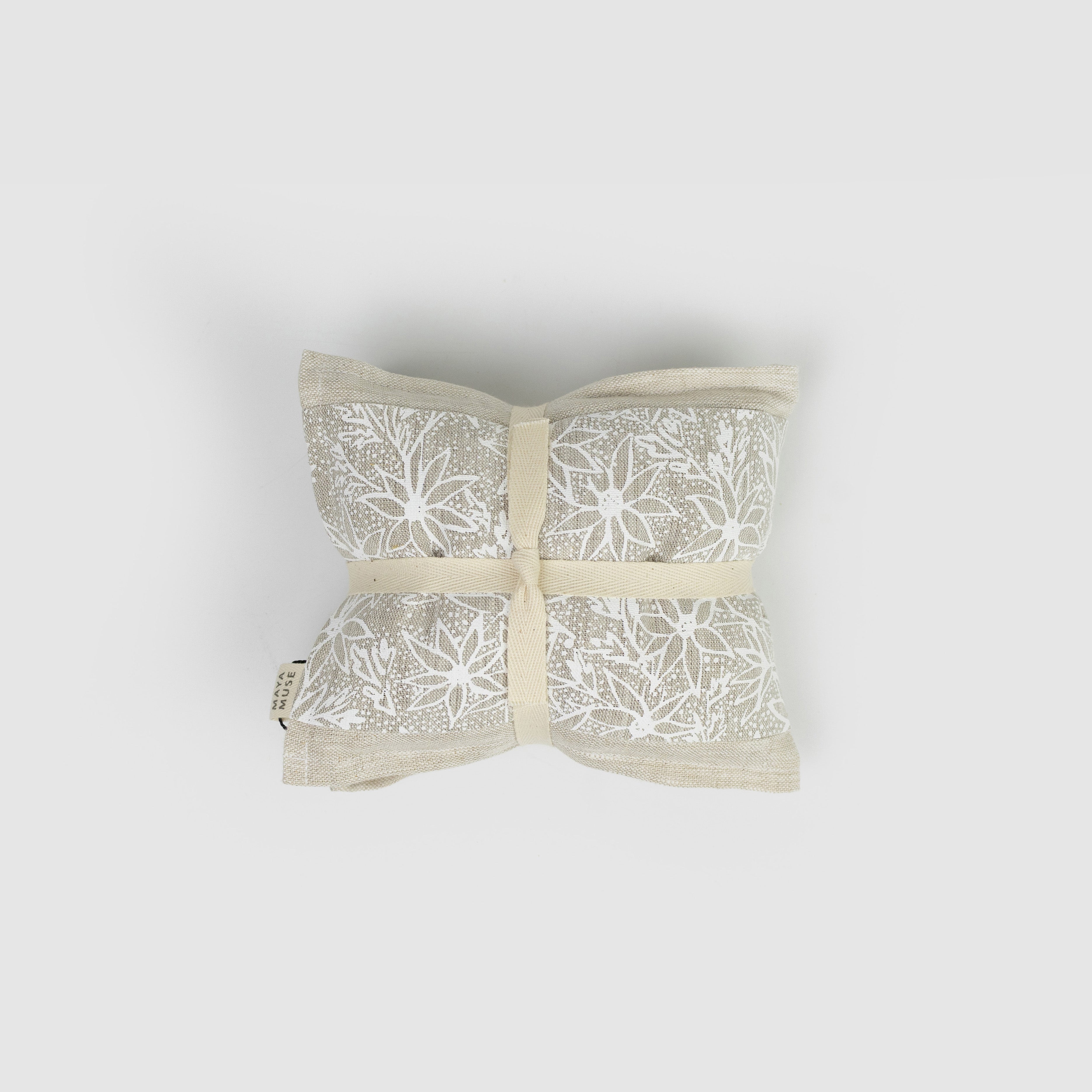 Decorative heat pack with white floral pattern on a light grey background