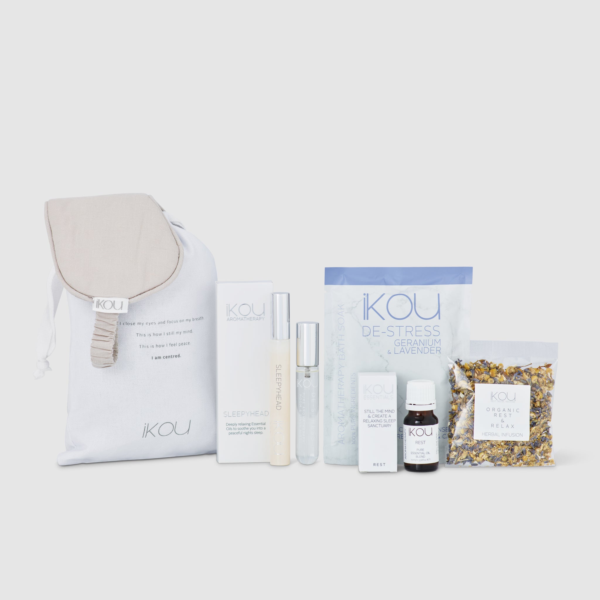 Collection of KOU wellness products including a eye mask, bottles, and a pouch on a white background