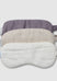 Set of three eye masks in purple, beige, and white on a light gray background