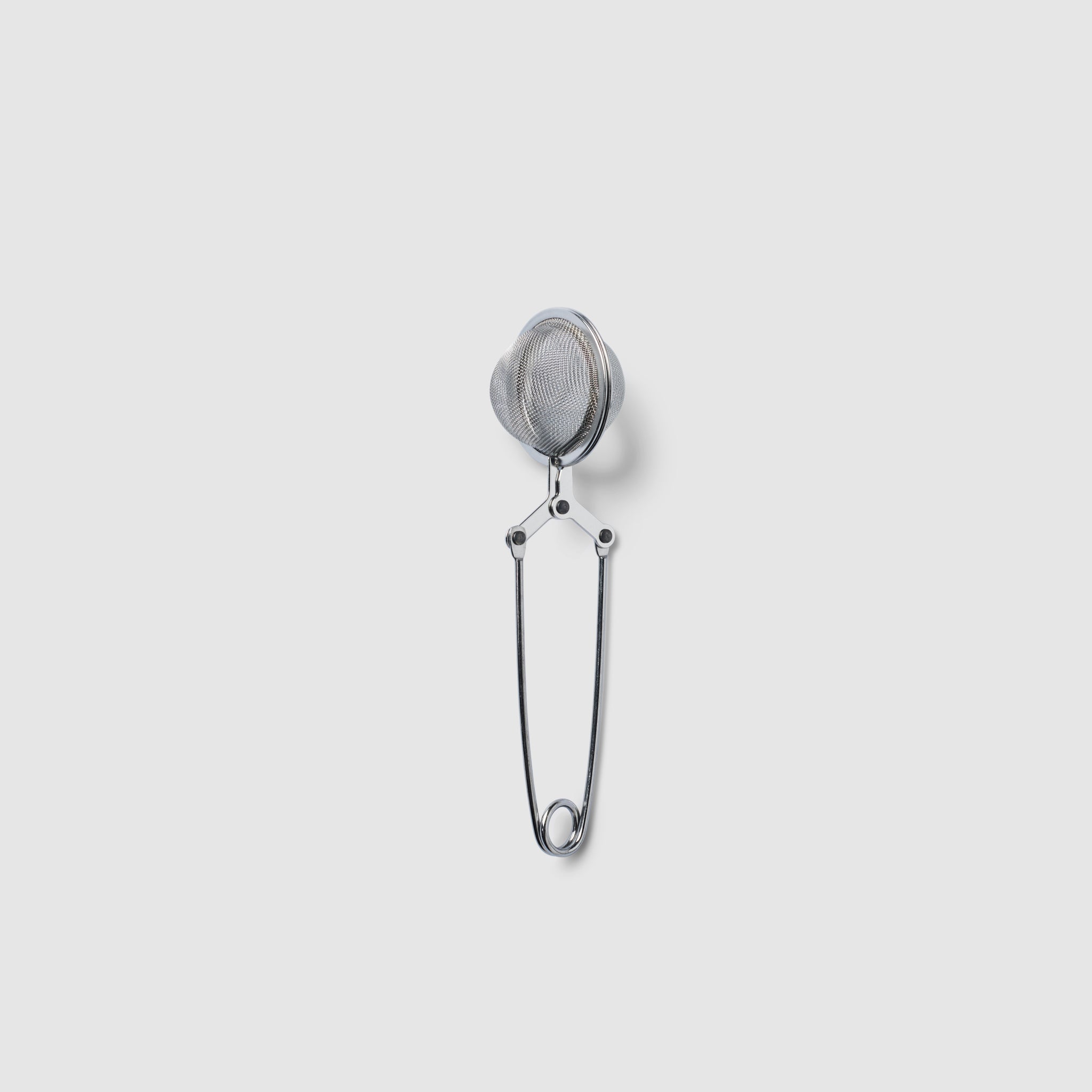 Metallic tea infuser on a light gray background