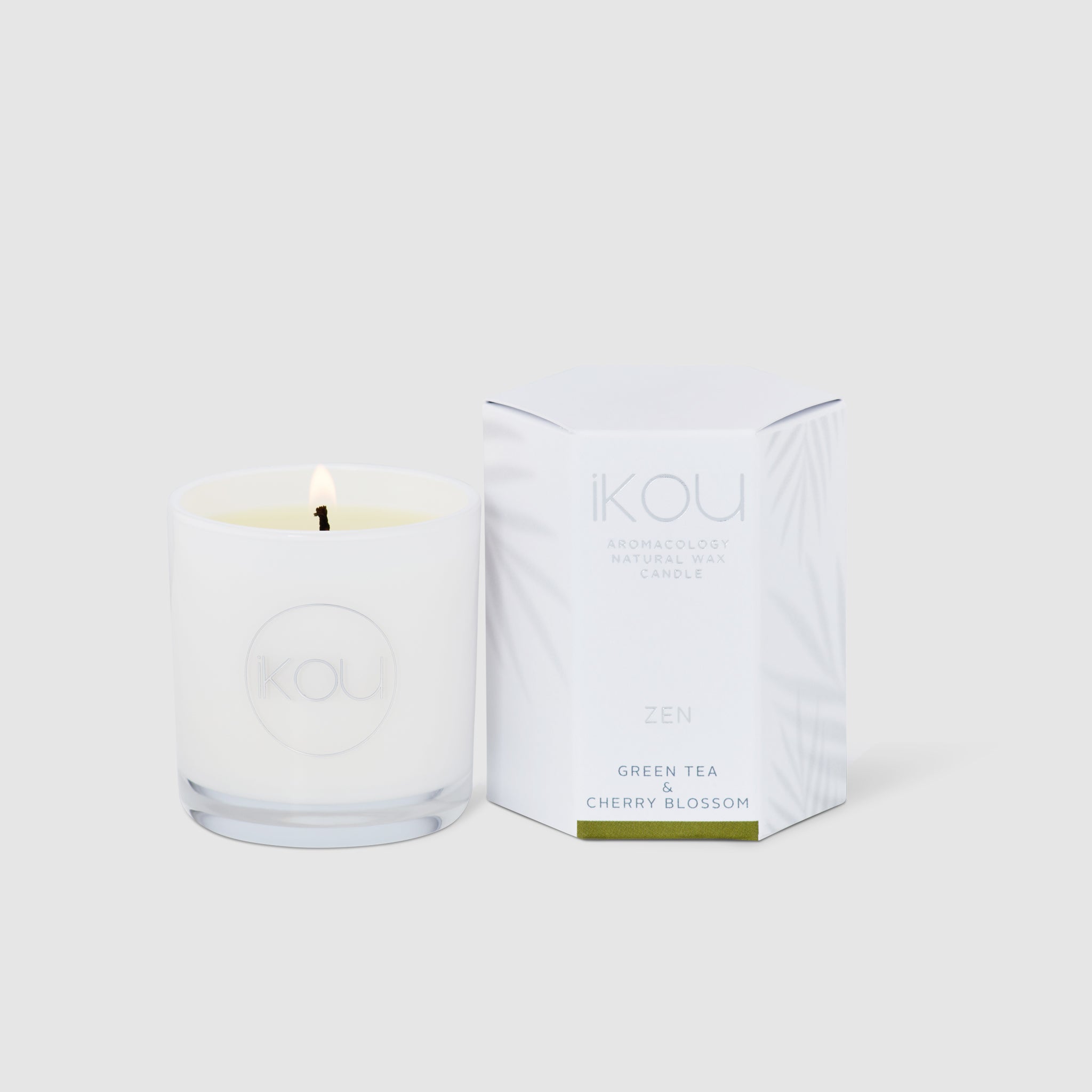 Candle with packaging labeled 'IKOU' on a white background